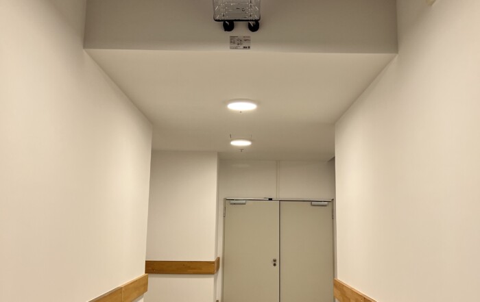 Neuer Flur mit weißen Wänden und Holzanprallschutz im Allee-Center