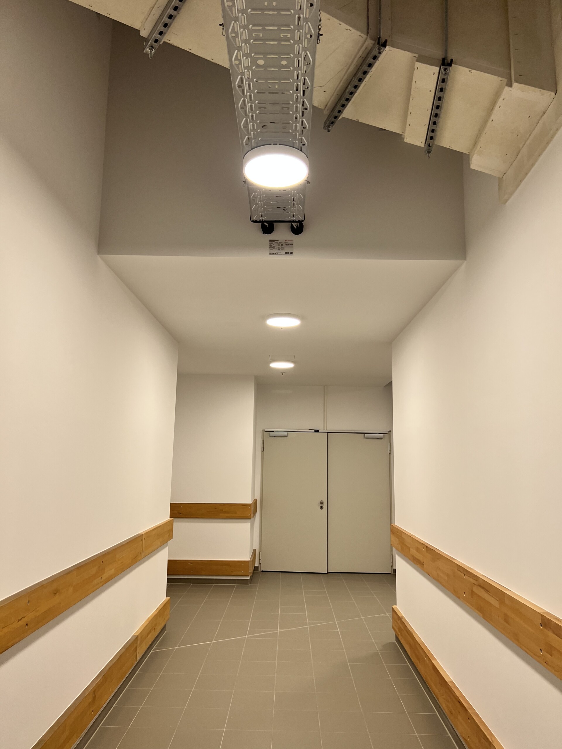 Neuer Flur mit weißen Wänden und Holzanprallschutz im Allee-Center