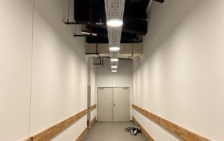 Neuer Flur mit weißen Wänden und Holzanprallschutz im Allee-Center