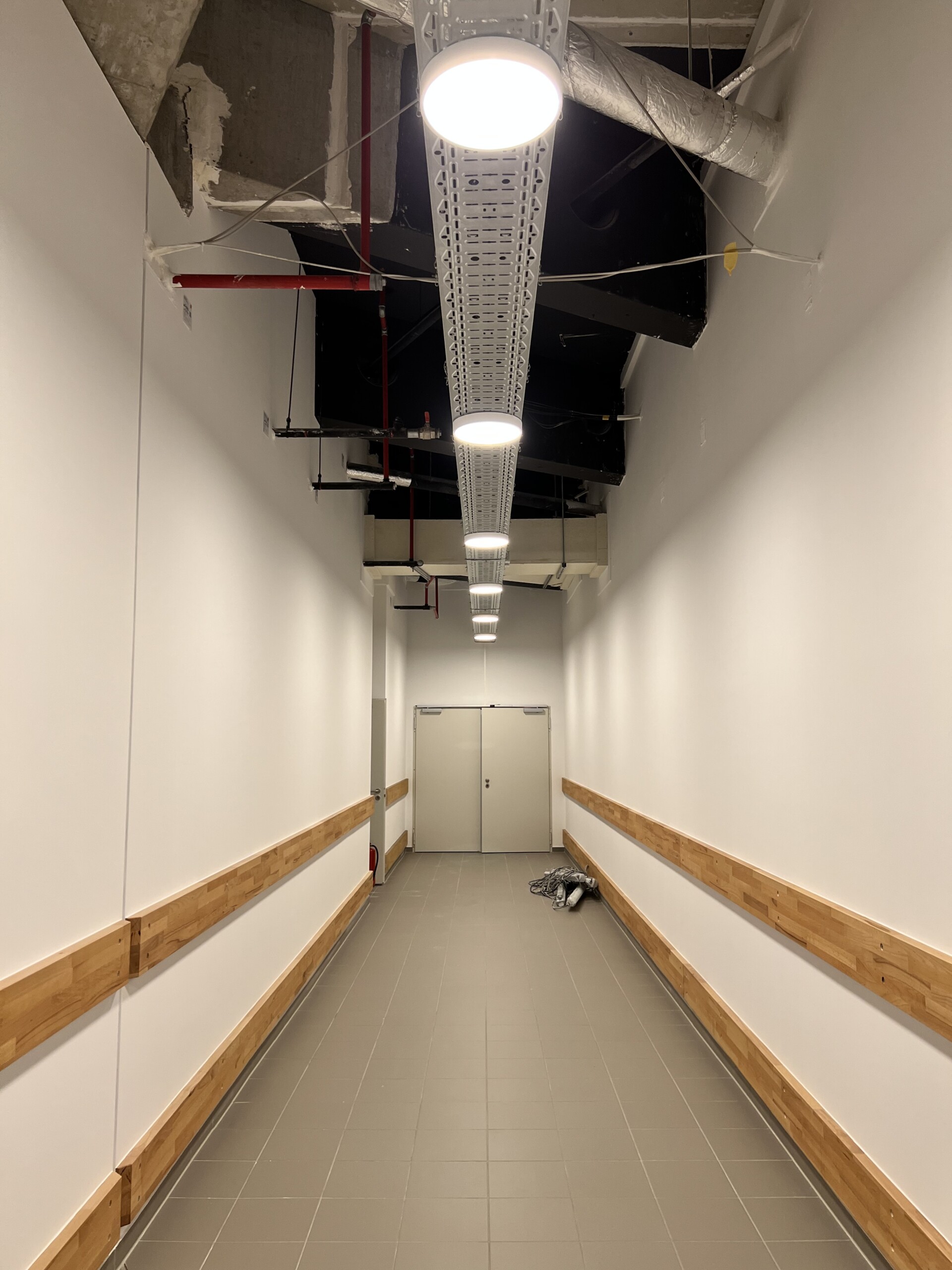 Neuer Flur mit weißen Wänden und Holzanprallschutz im Allee-Center